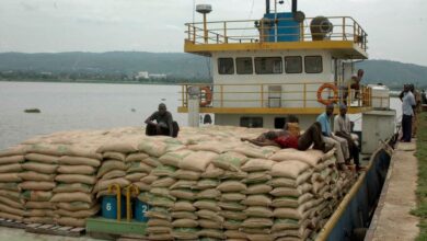 Workers offload sugar imported from Uganda at Kisumu port.